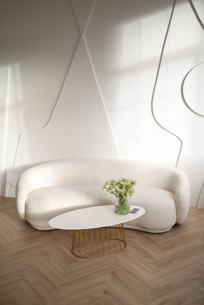 about-img-01 Elegant living room with a sleek white sofa, stylish table, and soft lighting.