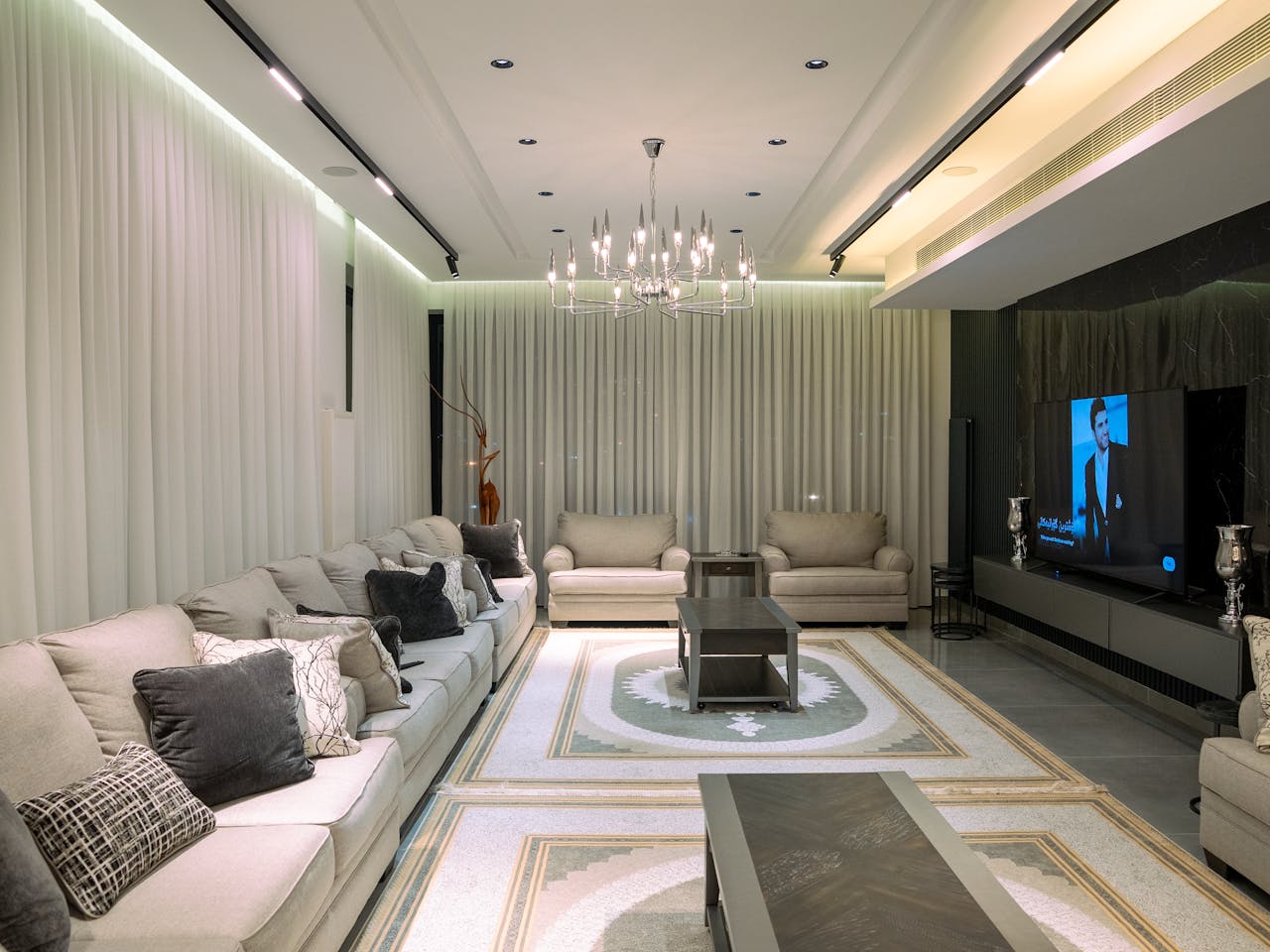 gallery-01 Luxurious living room featuring sleek furniture and a modern chandelier.