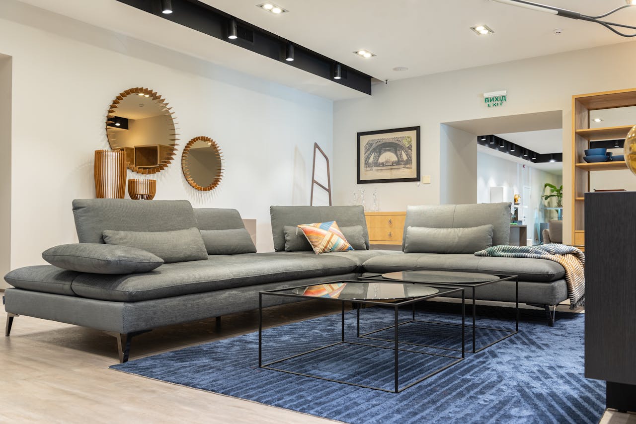 Contemporary living room interior featuring a gray sofa, mirrors, and elegant design elements.