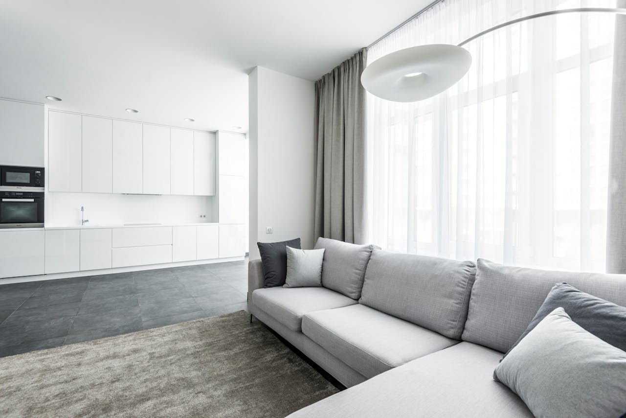 journey-02 Bright modern living area featuring a cozy sofa and minimalist kitchen background.